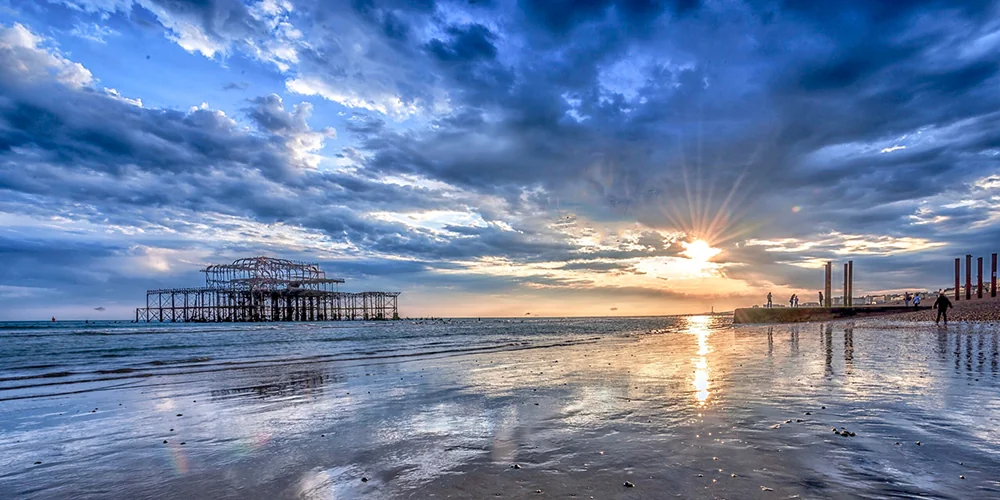The remains of West Pier on Brighton beach at sunset